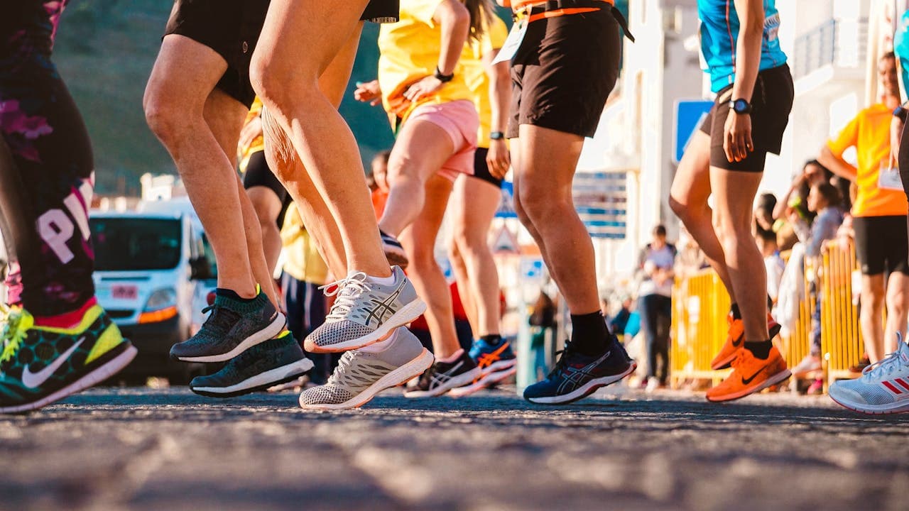 Runners in running shoes at the start of a road race